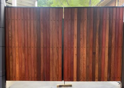 Stained hardwood double gates on a black steel frame