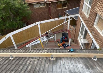 New timber pergola frame over a deck, seen from a tiled roof