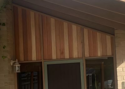 Gable entry clad in natural timber boards above the front door