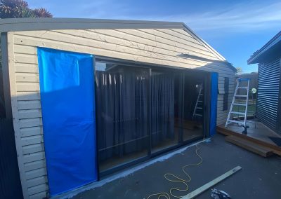Extension with new sliding doors and weatherboard walls during construction