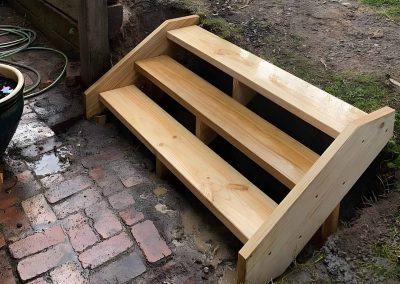 Treated pine steps leading down to a brick paved path
