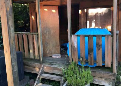 Old timber cubby house with a small deck and pergola