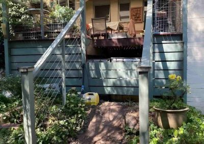 Brick garden path leading to a raised deck with grey balustrades