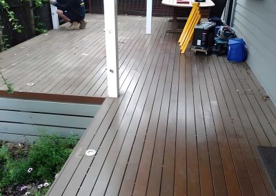 Grey-stained timber deck along the side of a house