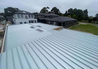 New light grey metal roof with skylights on a new build