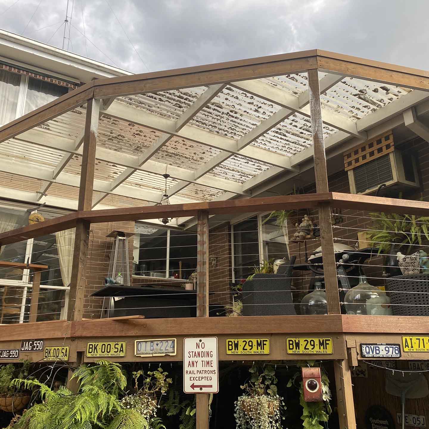 Before: old pergola with worn roof sheets over a raised deck