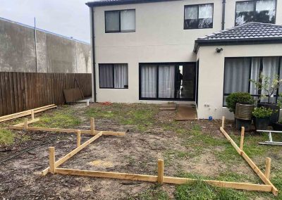 Before: bare backyard with timber set-out for a new deck, wider view