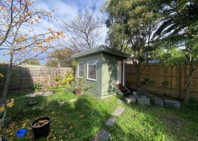 After: green weatherboard backyard studio, wider view