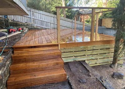 After: new hardwood deck with wide steps and a timber pergola frame